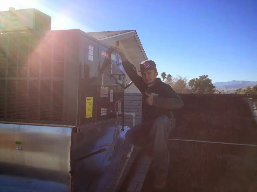 HVAC technician performing Heat Pump Repair on a rooftop unit in University of California-Santa Barbara